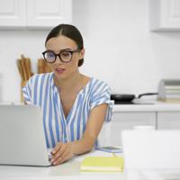 Woman working on laptop in kitchen