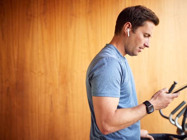 Man using smart treadmill and phone