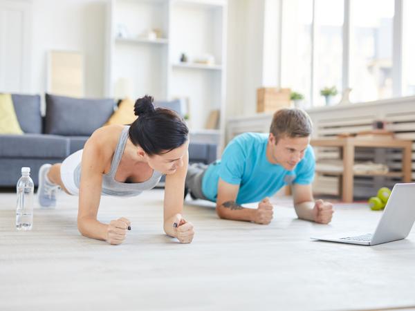 Couple doing plank exercise at home