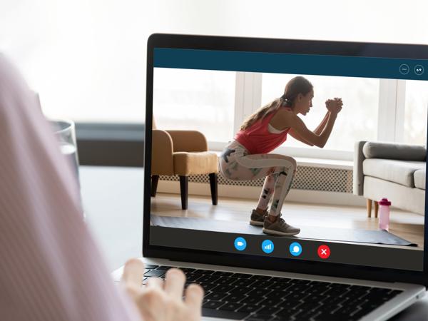 Woman using laptop for online fitness workout