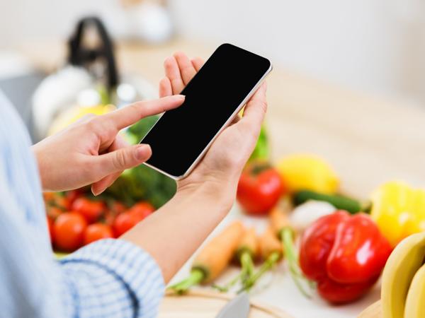 Woman using smartphone for healthy salad recipe