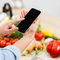 Woman using smartphone for healthy salad recipe