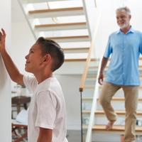 Grandfather and grandson using smart thermostat