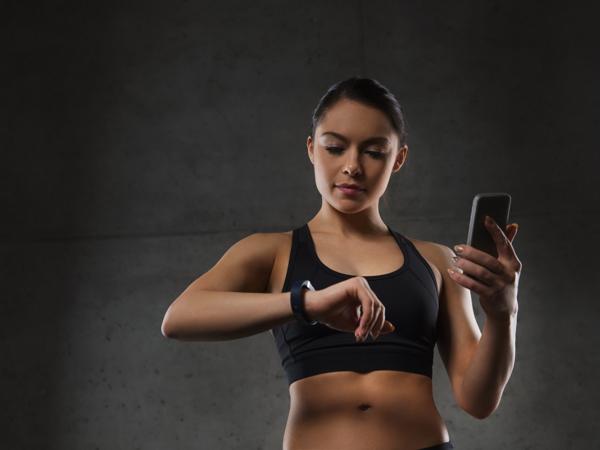 Woman using fitness tracker in gym